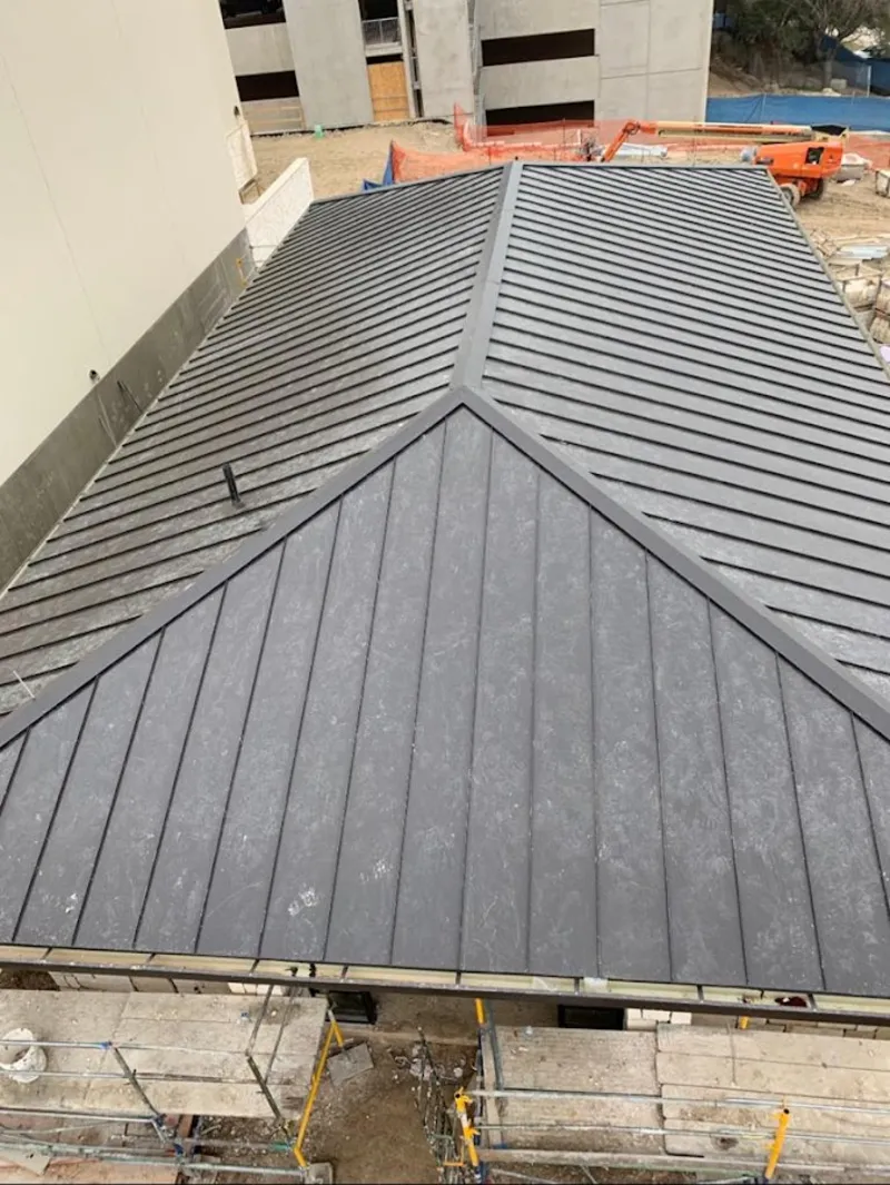 Commercial metal roof construction with crane equipment in Lake Park